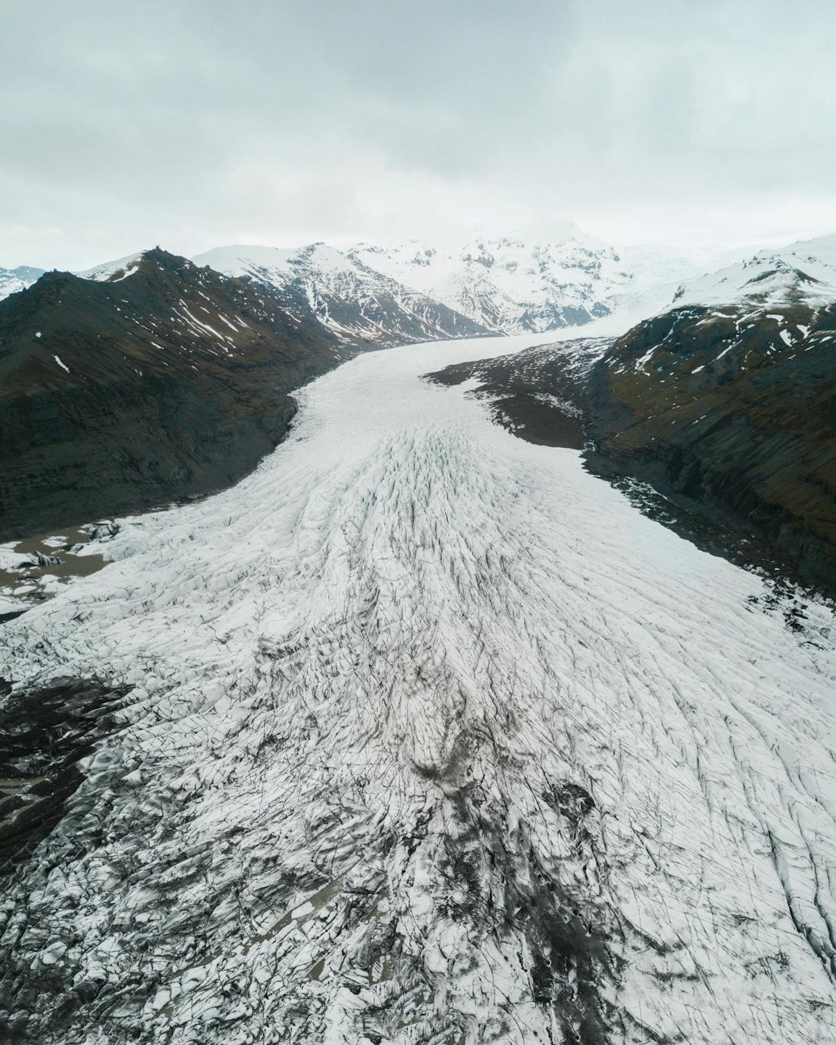 Snow-covered Icelandic mountain range under winter sky