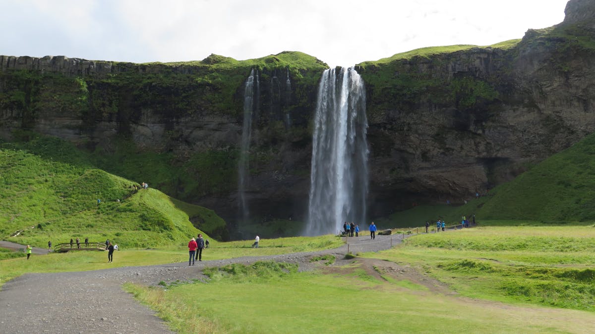 Tourist enjoying a powerful waterfall in Iceland