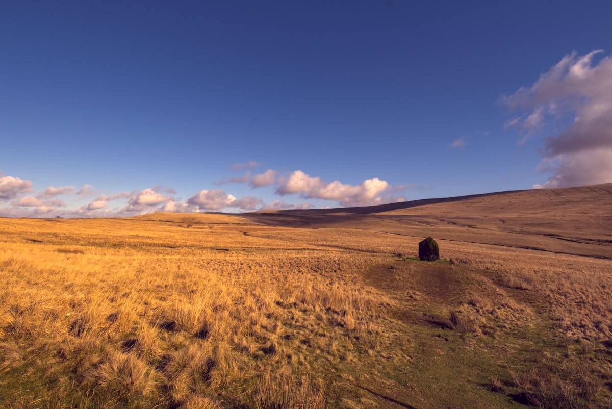 Ancient standing stone in a sweeping Welsh landscape