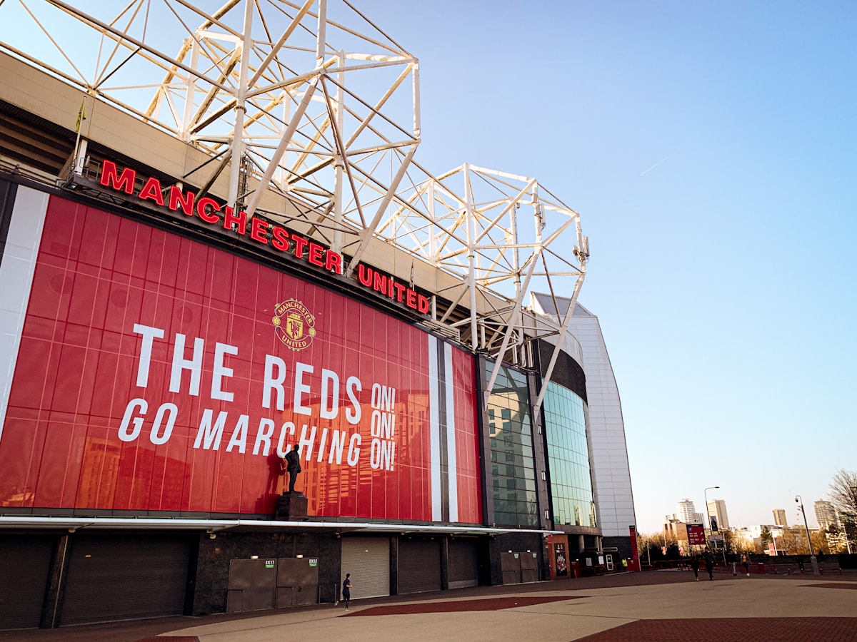 Old Trafford, home of Manchester United — a club whose name signals "unity" but was born from a railway works team rebrand, not a merger