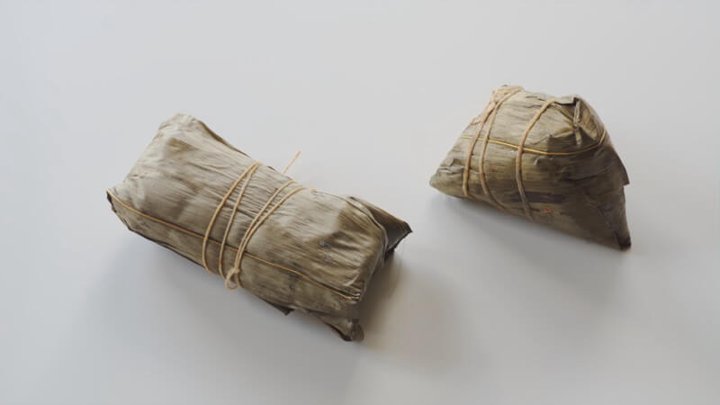 Two styles of zongzi with different leaf wrappings
